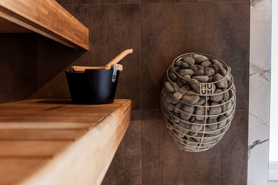 Private home sauna interior with wooden benches and stone heater