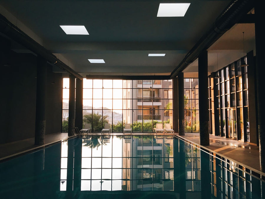 Indoor pool amenity with floor-to-ceiling windows at golden hour